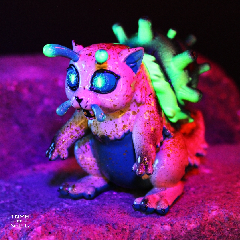 A photo of a sculpture of a snail-cat kaiju with a speckled cream and green color scheme under UV light, which makes the green florece brightly in the eyes, feelers, and shell.