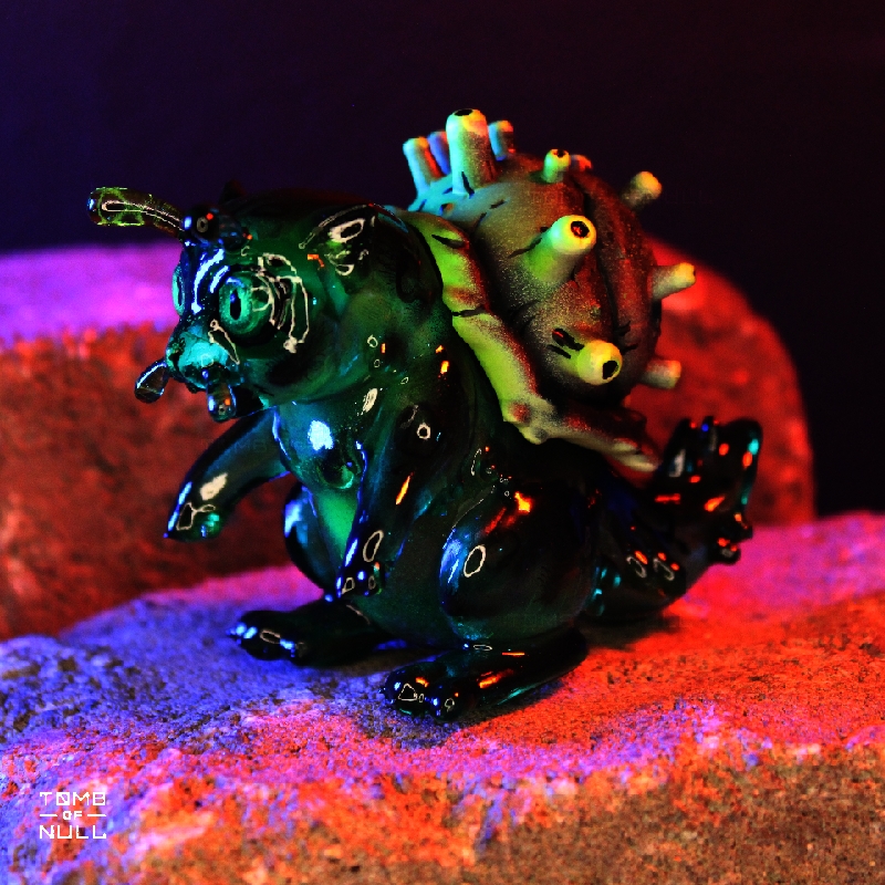 A photo of a sculpture of a snail-cat kaiju with a dark green and black color scheme.