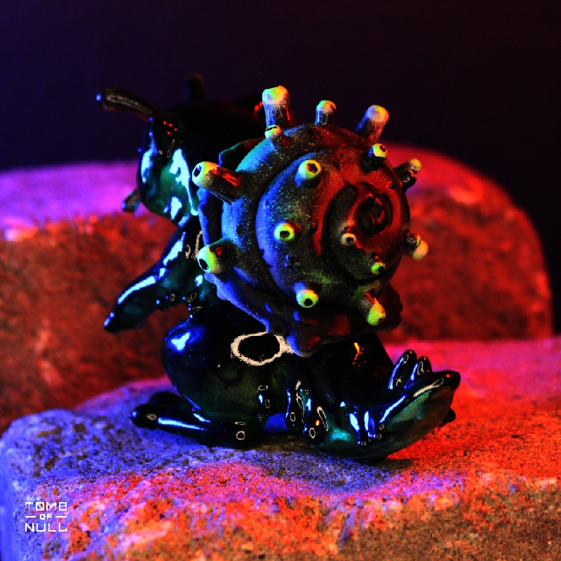 A photo of a sculpture of a snail-cat kaiju with a dark green and black color scheme.