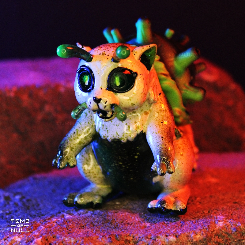 A photo of a sculpture of a snail-cat kaiju with a speckled cream and green color scheme.